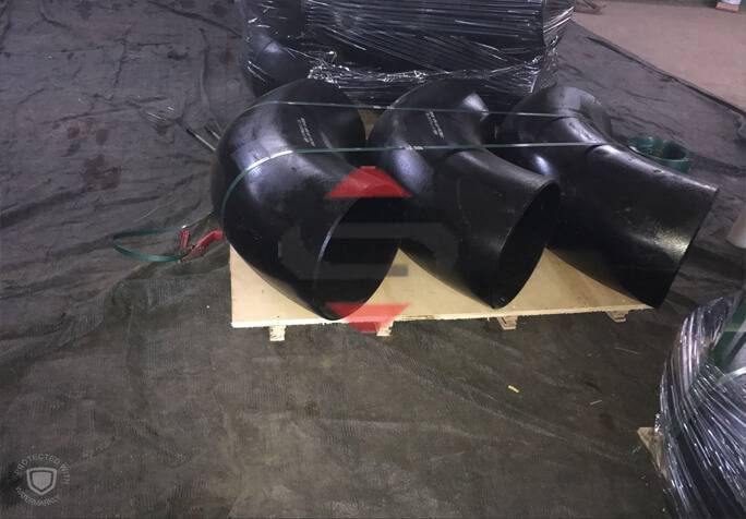 A Group Of Buttweld Pipe Fittings On A Wooden Surface